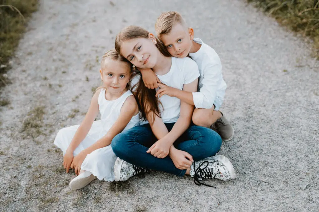 Zwei Geschwister bei natürlichem Outdoorshooting im Abendlicht auf einem Feldweg bei Rottweil im Schwarzwald